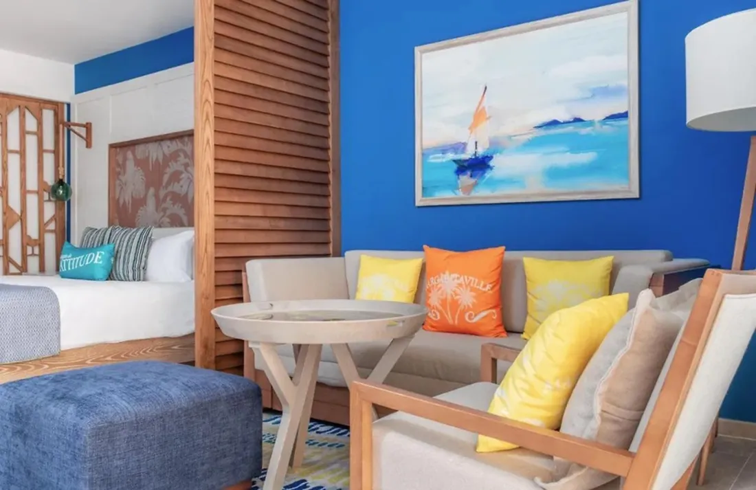 Sala con obra de velero sobre pared azul