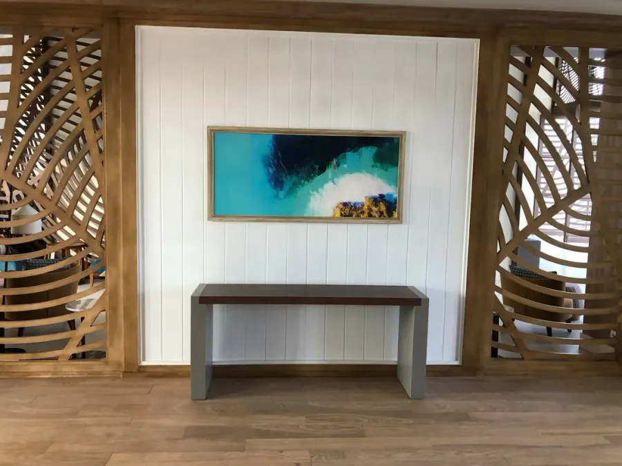 Obra abstracta en tonos turquesa entre celosías de madera