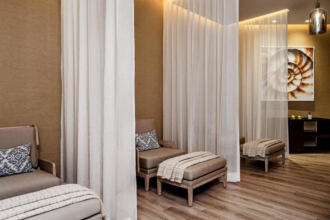 Lounge del spa con obra de nautilus y cortinas ligeras